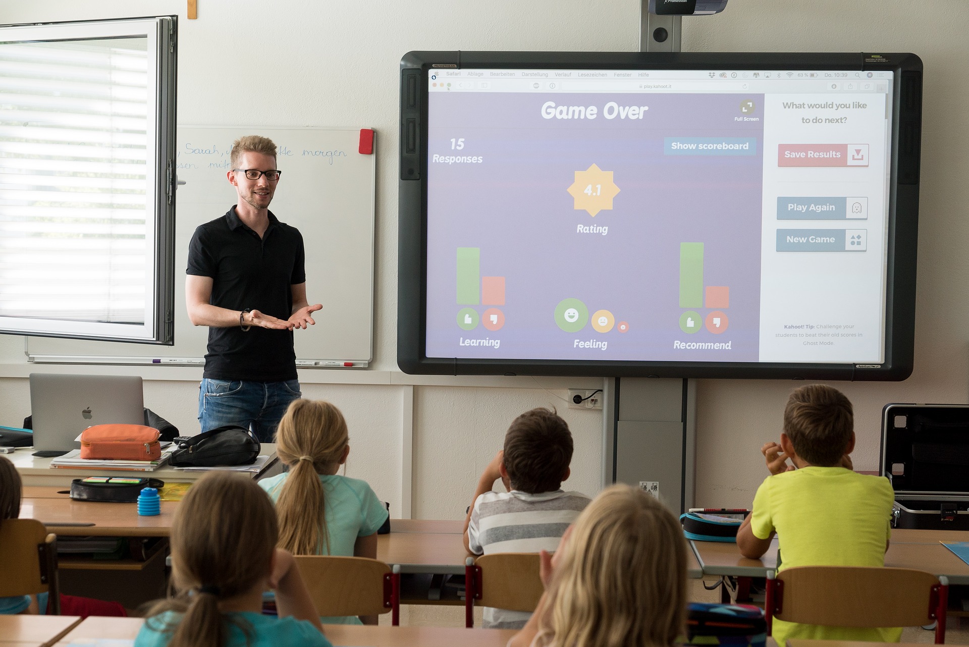Bild eines Lehrers vor einer Schulklasse mit einem Multimediaboard.